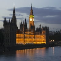 Zgrada i satni toranj duž ivice vode osvijetljeni u sumrak; London, Engleska Poster Print