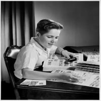 Dječak koji gleda poštanske marke kroz print plakata povećavanog stakla